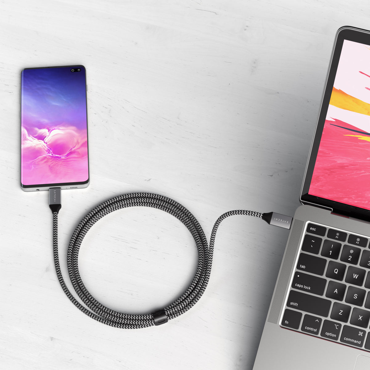 USB-C to USB-C 100W Charging Cable in Space Gray charging a phone from a laptop