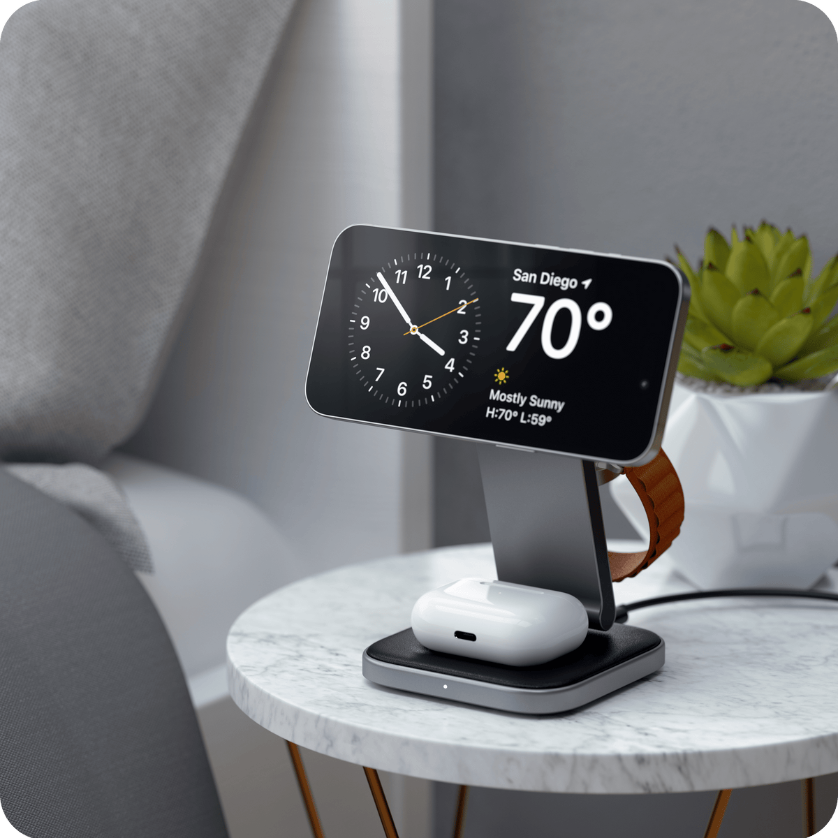 Satechi 3-in-1 Foldable Qi2 Wireless Charging Stand on a nightstand, charging an iPhone in StandBy mode, AirPods and an Apple Watch