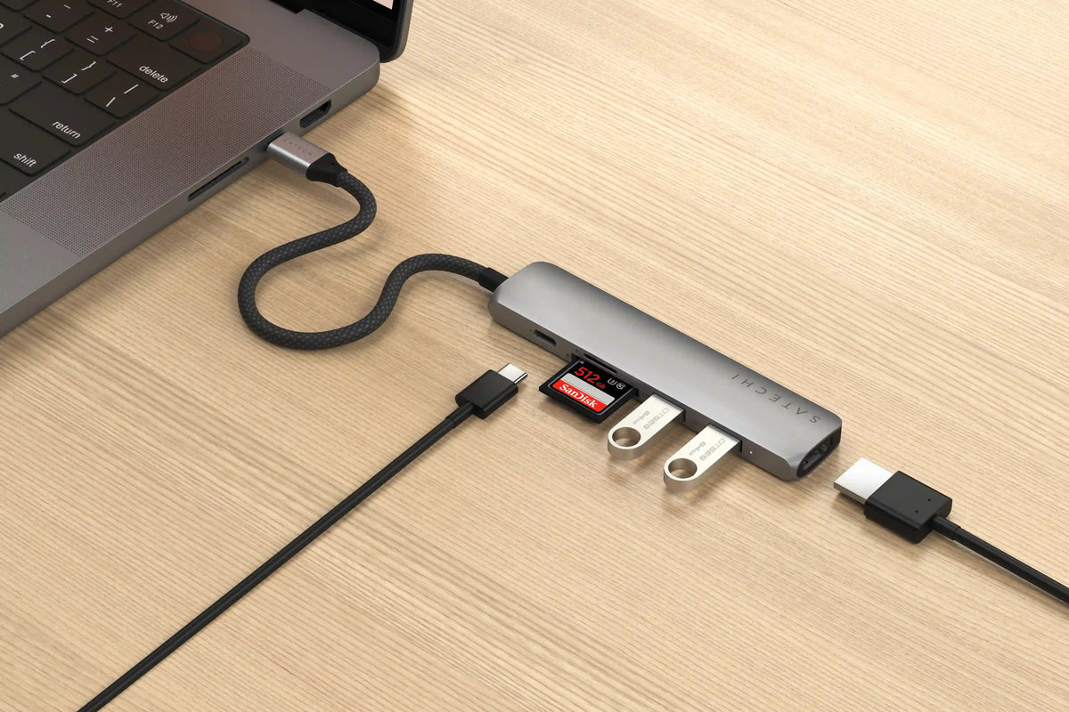 6-in-1 USB-C Slim Multiport Adapter in Space Gray plugged into a laptop with card, flash drives, USB-C and HDMI cables connected