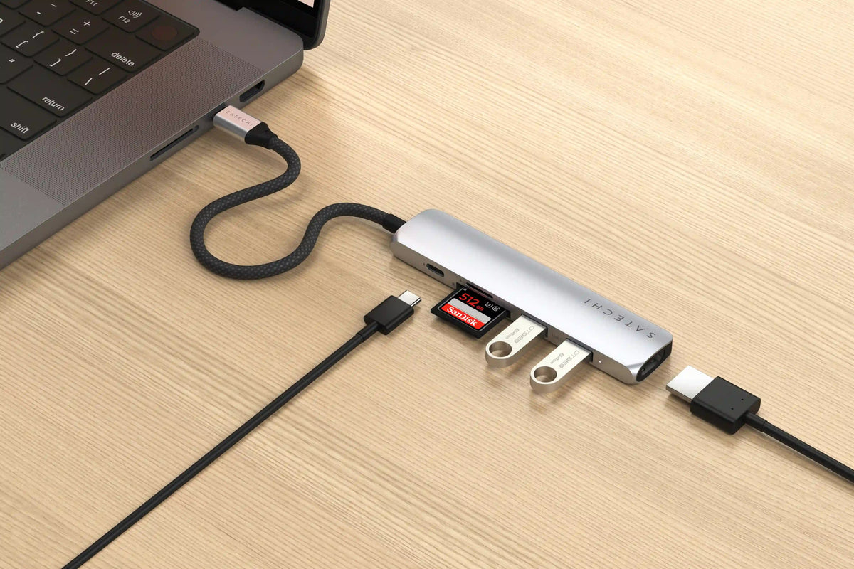 6-in-1 USB-C Slim Multiport Adapter in Silver plugged into a laptop with card, flash drives, USB-C and HDMI cables connected