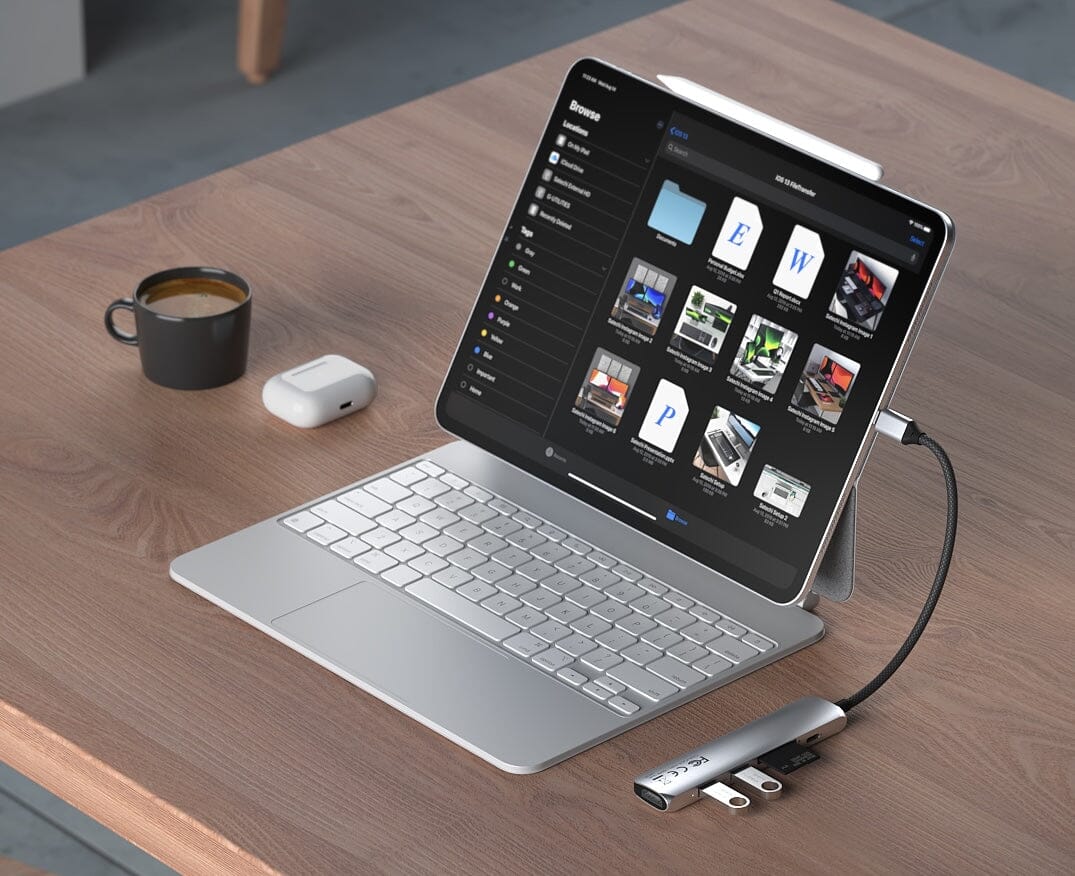 6-in-1 USB-C Slim Multiport Adapter in Silver connected to an iPad with keyboard on a wooden table