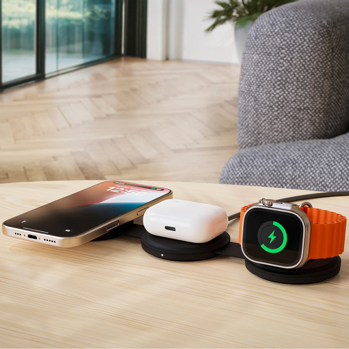 Satechi OntheGo 3-in-1 Charger in Black on a table, charging an iPhone, AirPods and an Apple Watch