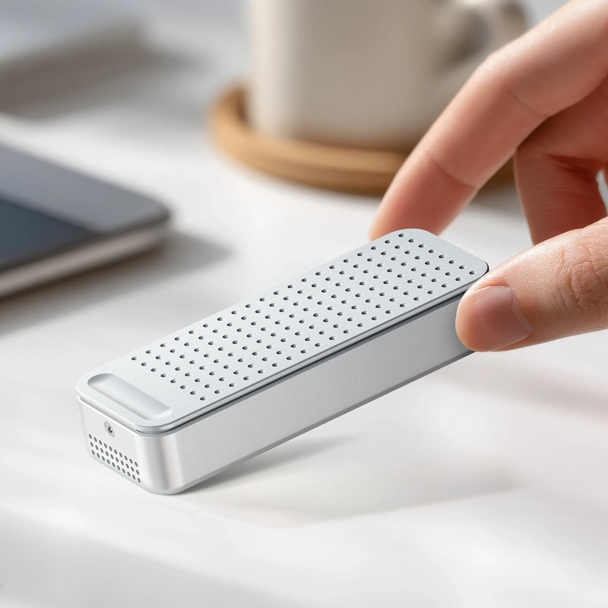 Hand holding the DotDisk 80Gbps SSD Enclosure in Silver on a desk
