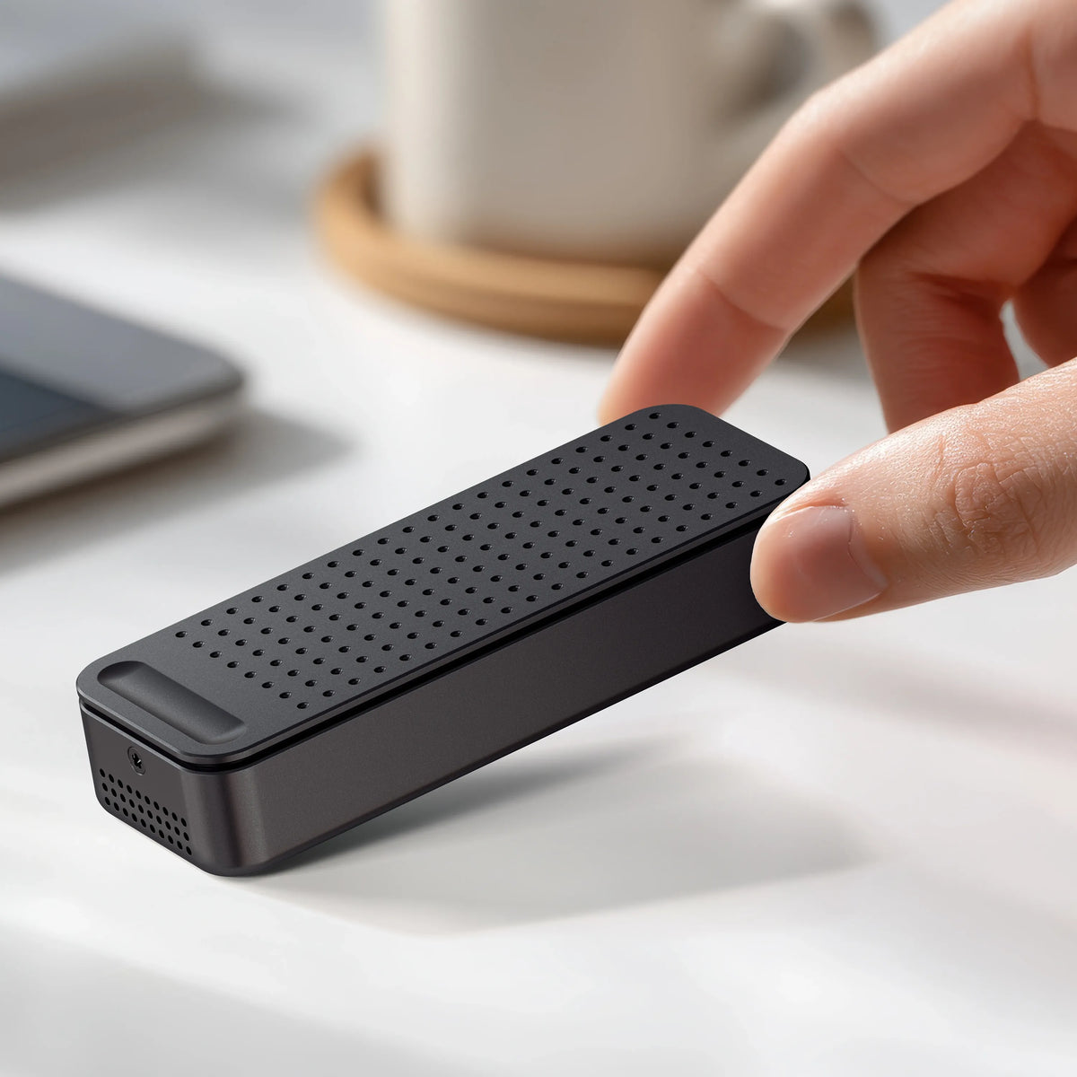 Hand holding the DotDisk 80Gbps SSD Enclosure in Space Black on a desk