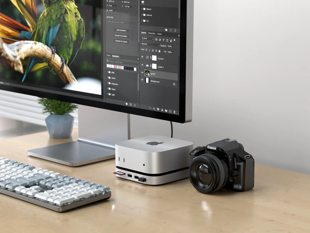 The Mac Mini M4 Stand & Hub with SSD Enclosure used to upload images from SD card and USB-C drive. On the iMac, a photo is being edited on a editor software. 

