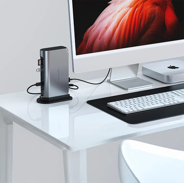 Satechi Thunderbolt 4 Multimedia Pro Dock standing upright on a white desk, connected to an iMac and Mac mini, with a white keyboard on a black desk mat.