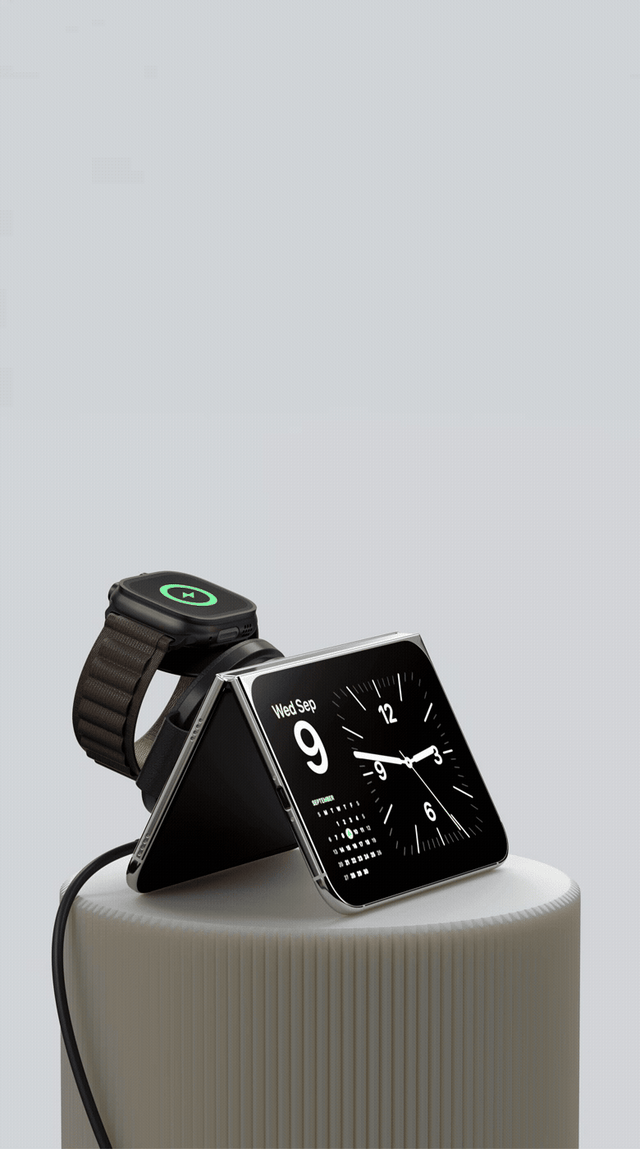 Satechi Duo foldable charger charging an Apple Watch on its magnetic puck, with a folded phone resting on it showing a clock and calendar for Wed Sep 9.