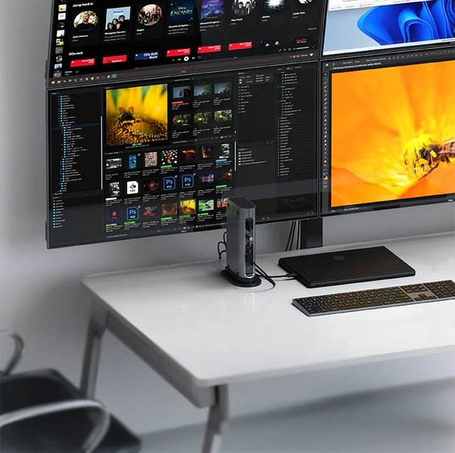 Satechi Thunderbolt 4 Multimedia Pro Dock on a white desk, connected to a Microsoft Surface laptop powering three monitors, with a wireless keyboard in front.