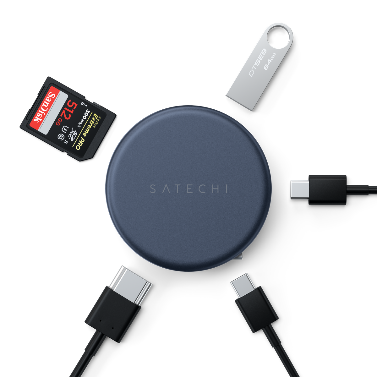 A OntheGo™ 5-in-1 Multiport Adapter in Indigo shown with various accessories including a SanDisk 128GB SD card, a silver USB flash drive, and three black USB-C to USB-C cables on a clean white background.