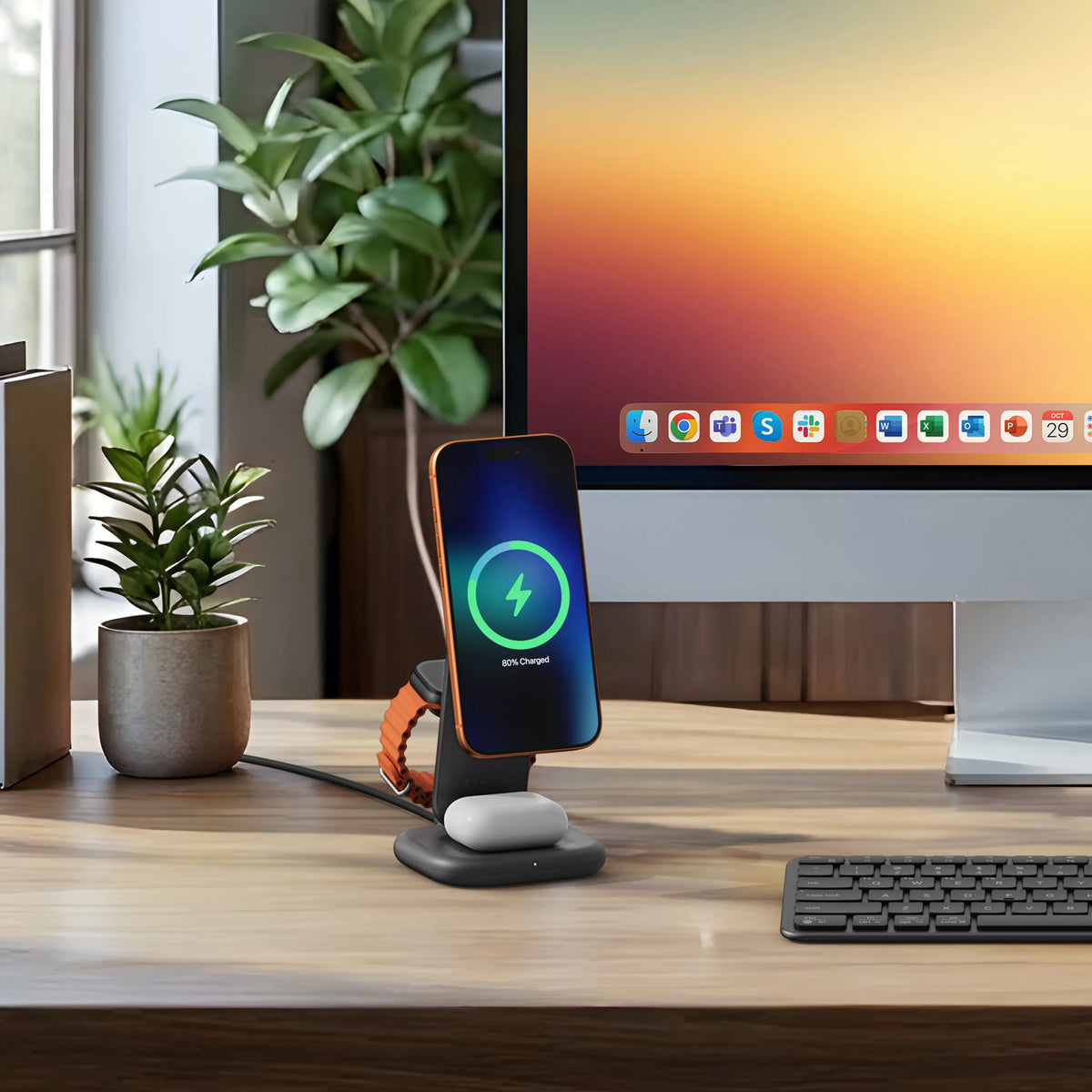 3-in-1 Foldable Wireless Charging Stand with Qi2 25W on a desk next to a monitor, charging an iPhone