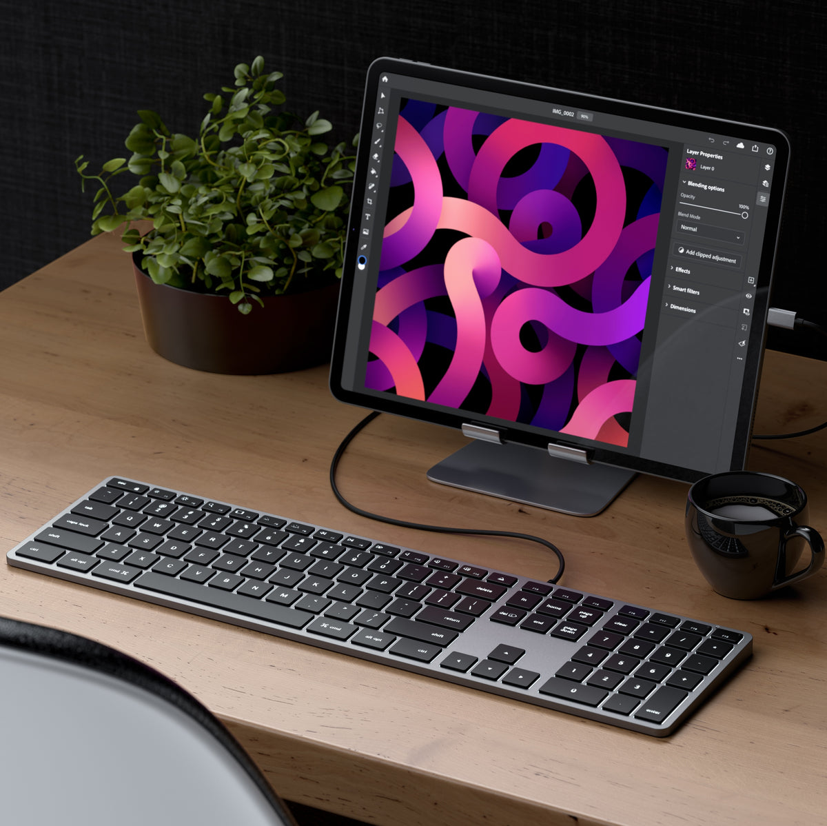 Satechi Slim W3 Wired Backlit Keyboard in Space Gray on a wooden desk, connected to an iPad on a stand