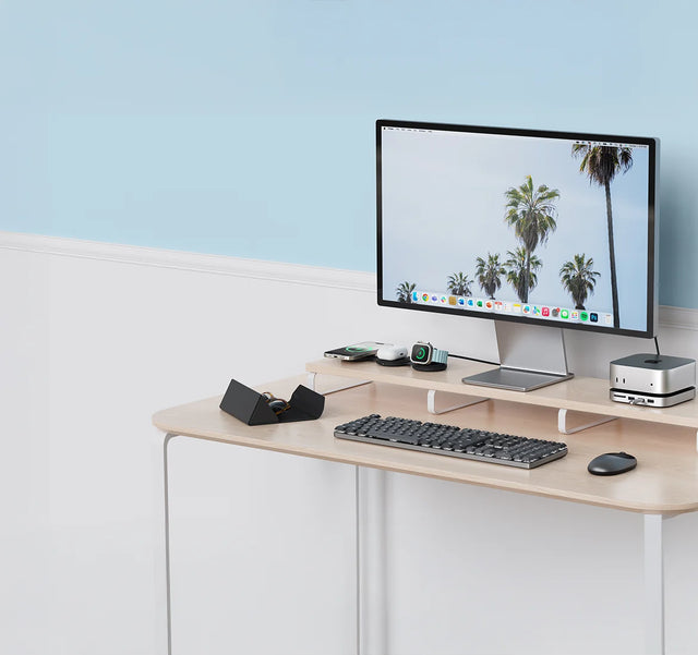 Desk setup with Satechi accessories, including an OntheGo™ 3-in-1 Charger for iPhone, AirPods and Apple Watch, a Mac mini stand Mac Mini M6/M5 Pro/M4 Stand & Hub with SSD Enclosure, Findall Glasses case, a dark SM3 Mechanical keyboard and a M1 mouse.