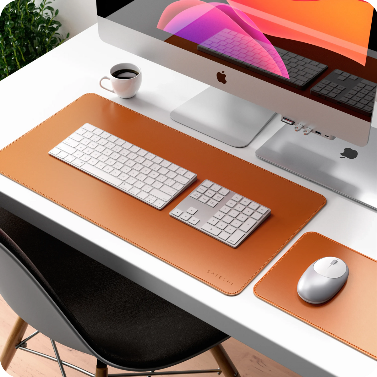 Bluetooth Extended Keypad in Silver next to a keyboard and mouse on a tan desk mat in front of an iMac