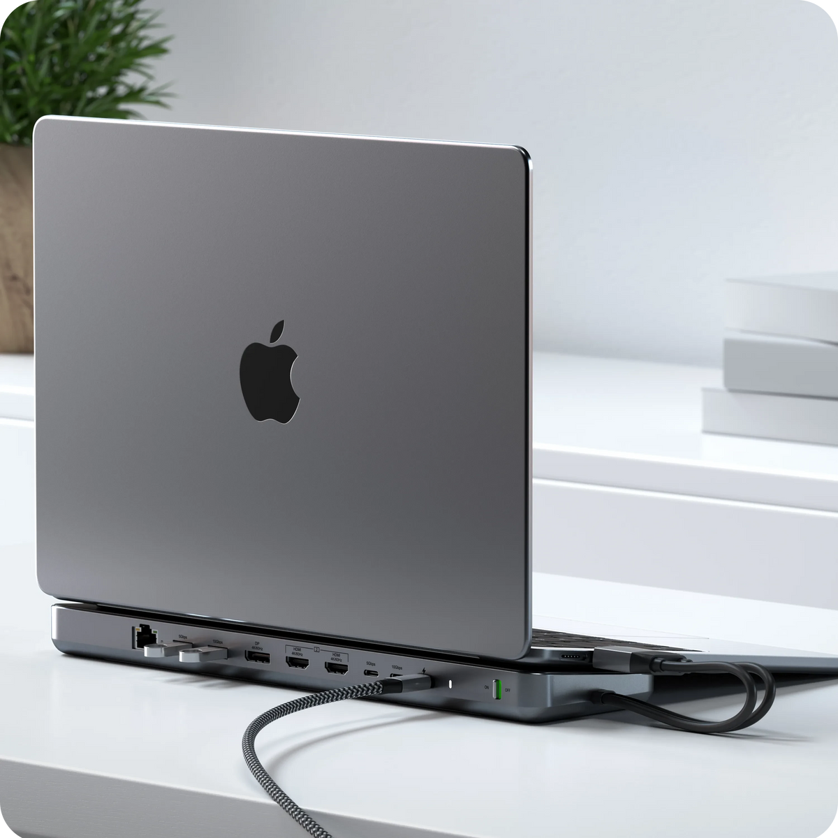 Dual Dock Stand Docking Station with NVMe SSD Enclosure under a MacBook Pro on a desk, with cables connected