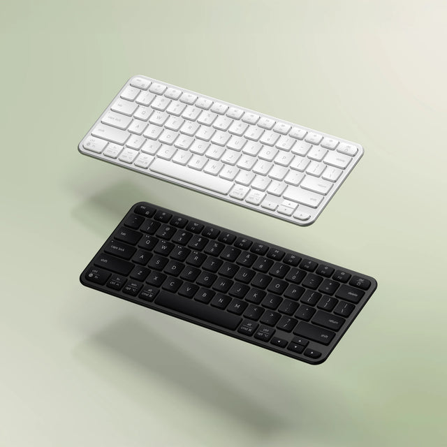 Two Slim EX1 Wireless Keyboards, one silver and one space black, on a light green background.