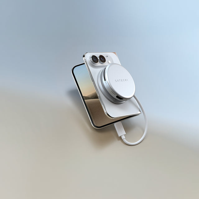 Silver Satechi OntheGo™ 5-in-1 Multiport Adapter with an HDMI port attached to the back of a white iPhone, with a short USB-C cable connected.