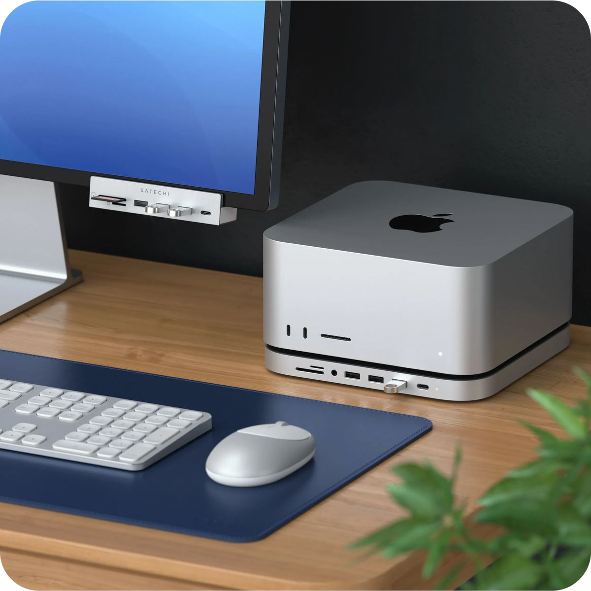 M1 Bluetooth Mouse in Silver on a desk mat next to a Mac Studio and keyboard