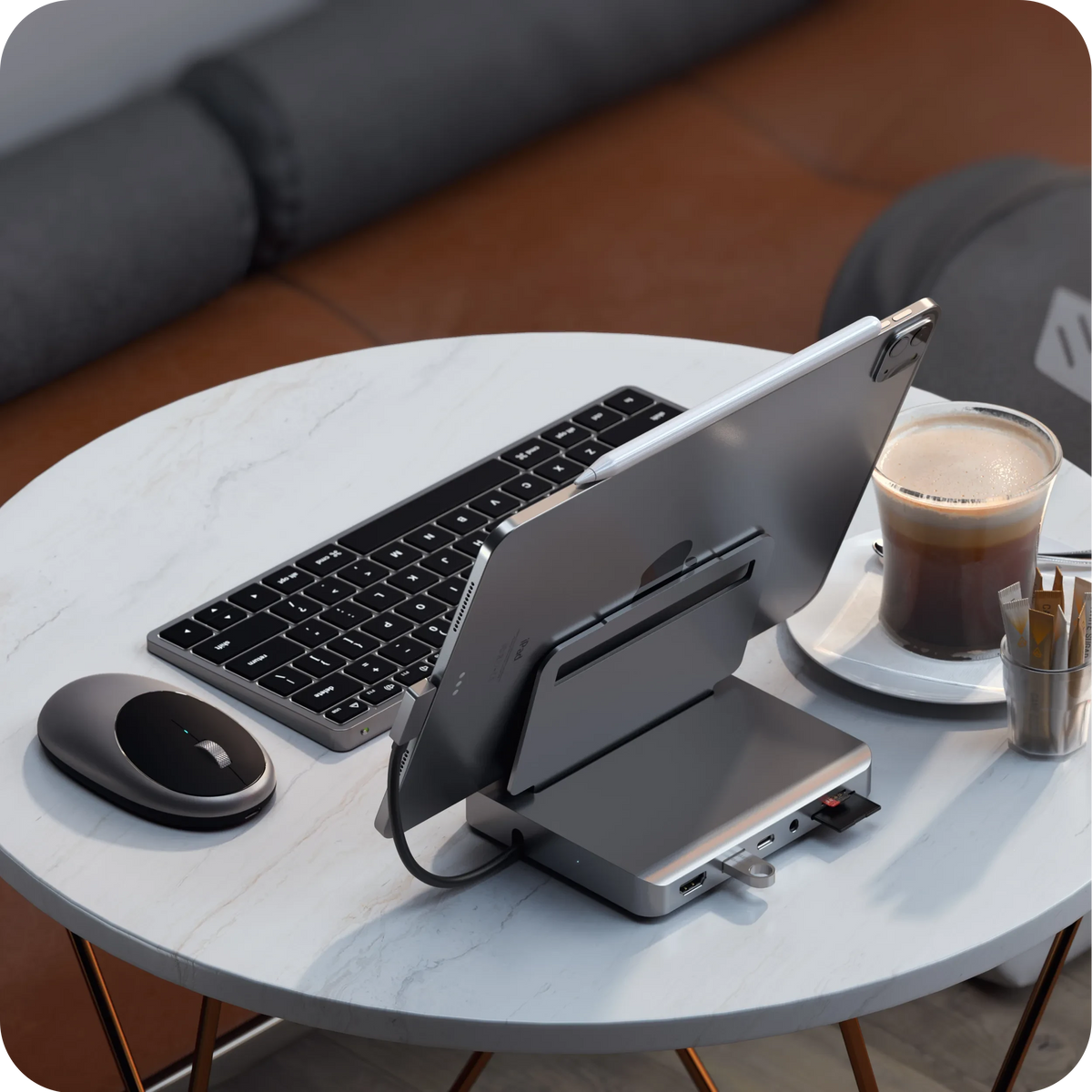 M1 Bluetooth Mouse in Space Gray on a marble table with a keyboard, iPad on a stand hub and coffee