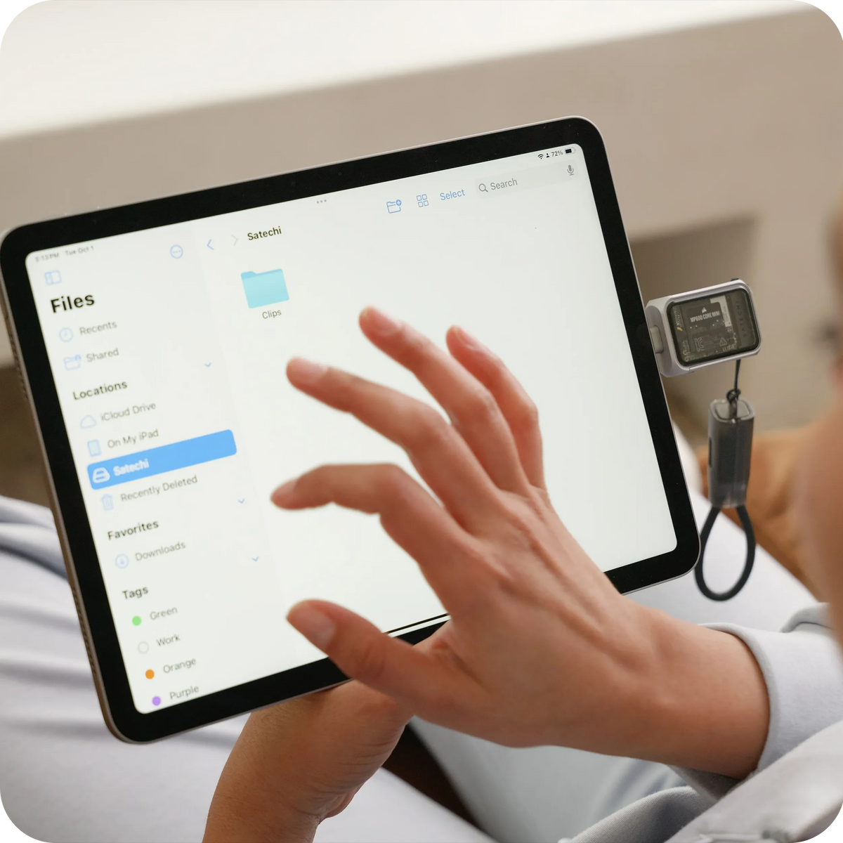 Satechi Mini NVMe SSD Enclosure plugged into an iPad, with a hand browsing the drive in the Files app