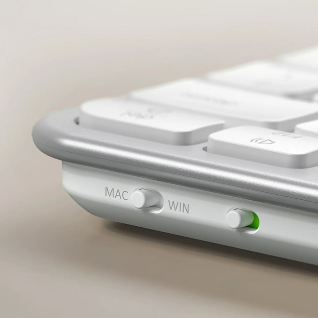 Close up of the white Satechi Slim EX1 Wireless Keyboard edge, showing the MAC/WIN toggle switch and power switch.