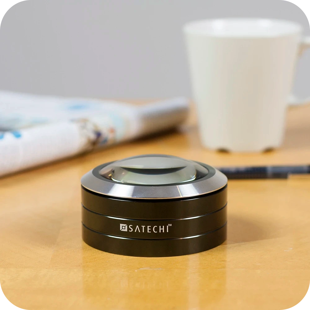ReadMate LED Desktop Magnifier on a wooden table next to a newspaper and mug