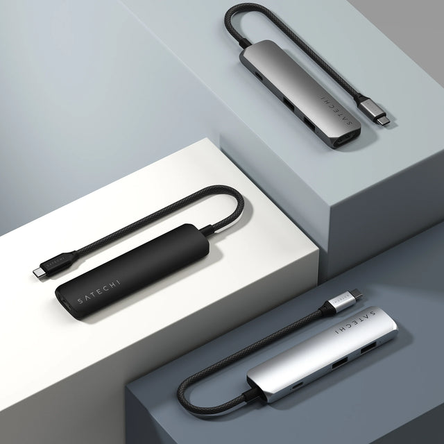 Satechi 4‑in‑1 USB‑C Slim Multiport Adapter 4K displayed in three finishes—space gray, black, and silver—showing the slim design and flexible USB‑C cable.