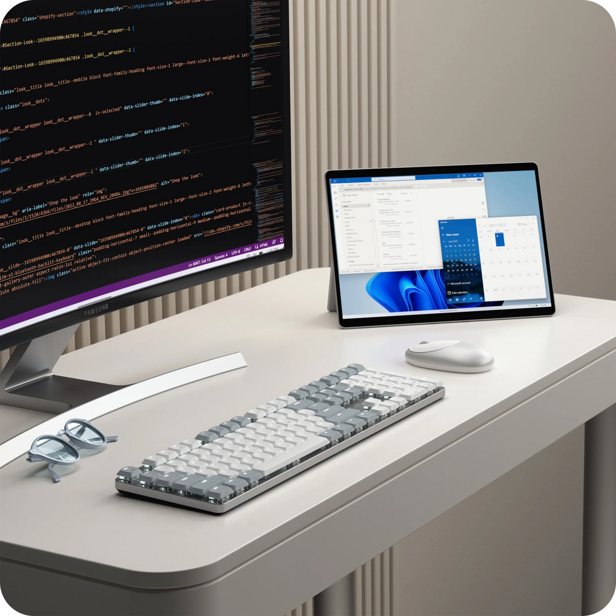 SM3 Slim Mechanical Backlit Bluetooth Keyboard in Light on a desk in front of a monitor and Surface tablet