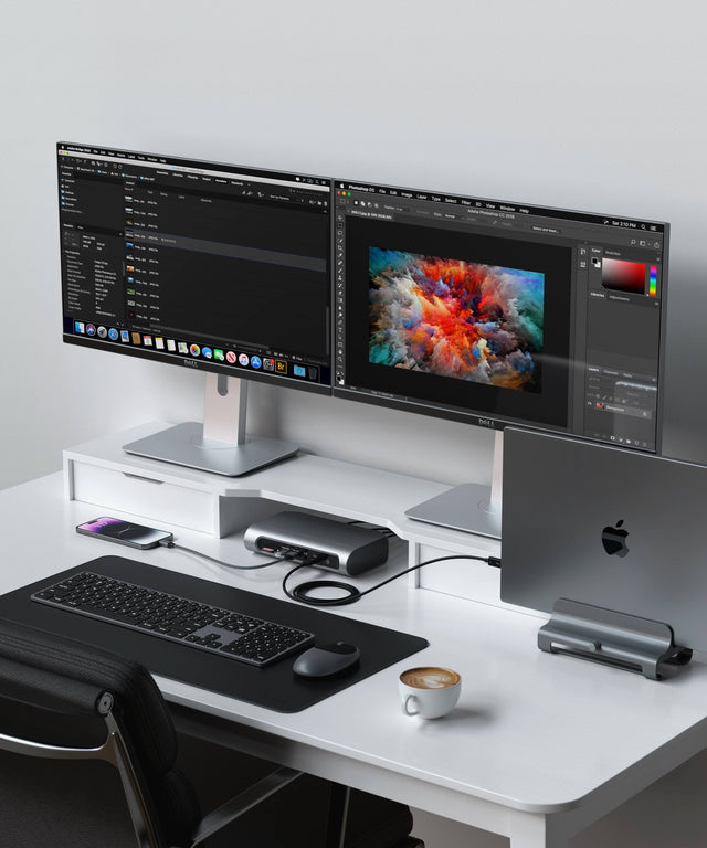 Satechi Thunderbolt 4 Multimedia Pro Dock on a white desk connecting a MacBook in a vertical stand to two Dell monitors, with an iPhone, keyboard, mouse and desk mat.
