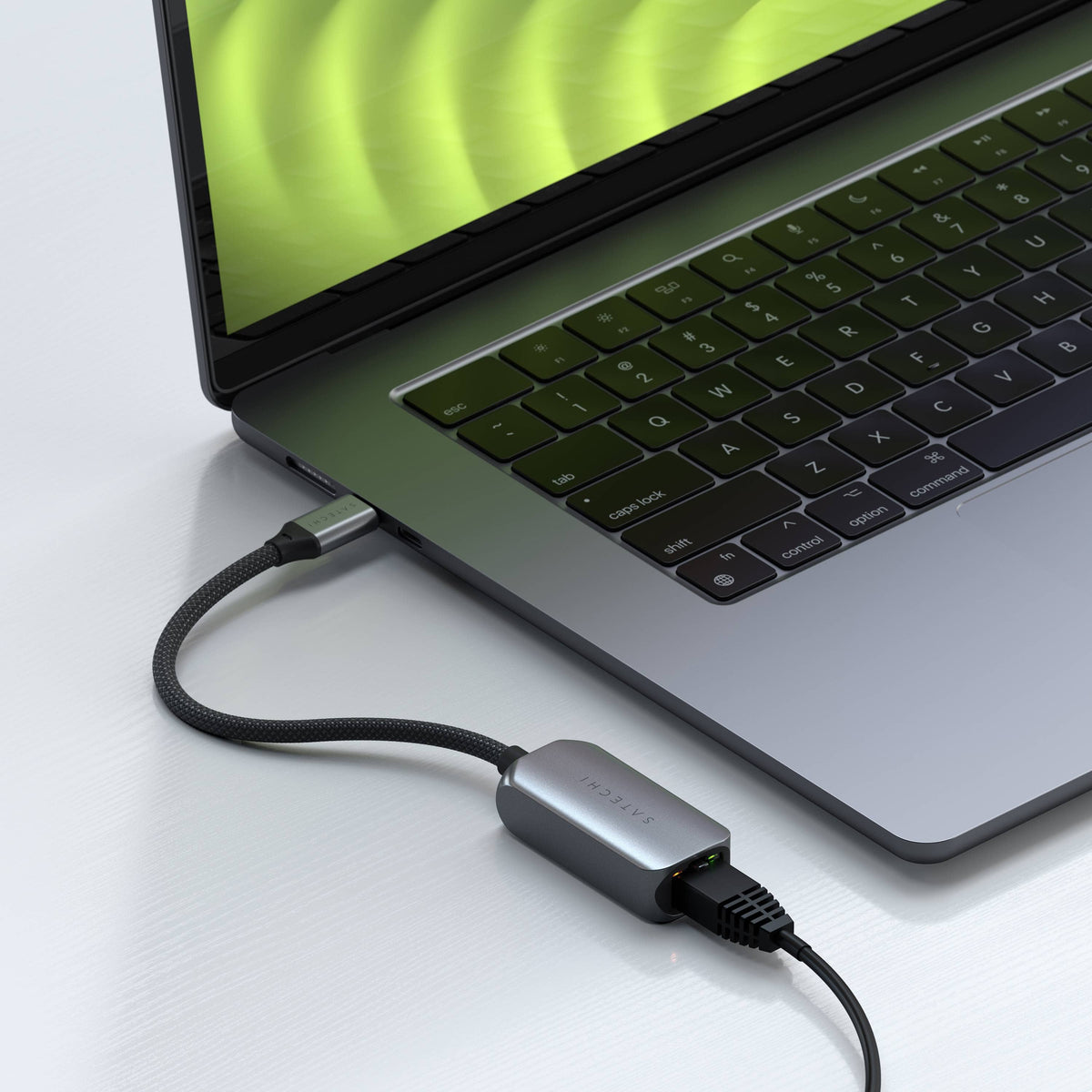 USB-C 2.5 Gigabit Ethernet Adapter plugged into a MacBook Pro with an Ethernet cable connected
