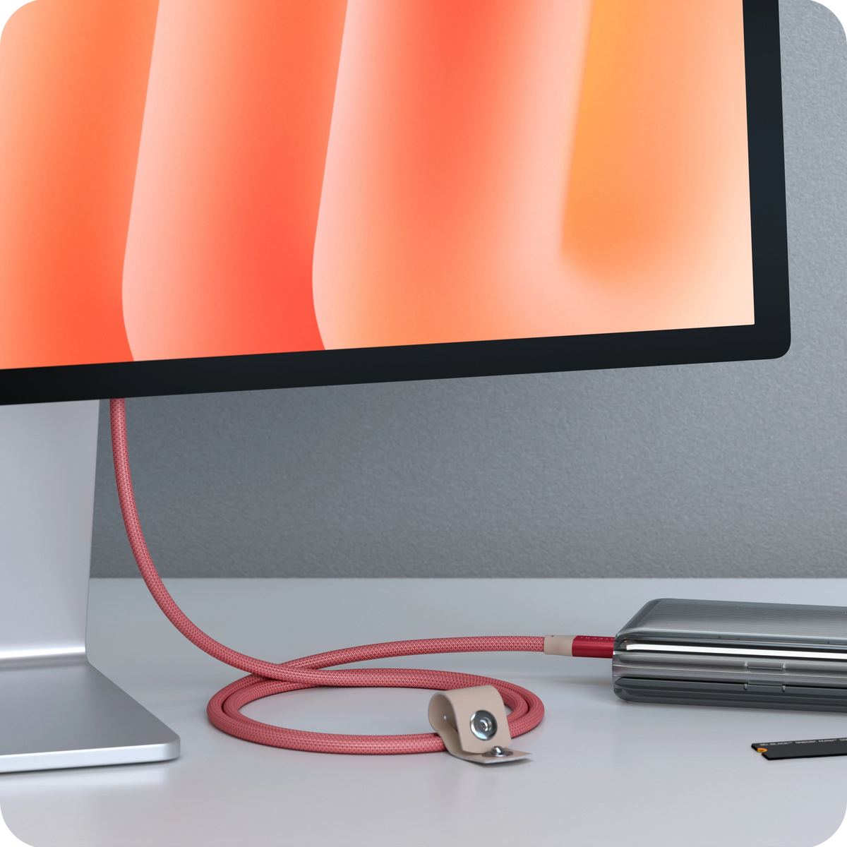 USB-C to USB-C Data and Charge Cable in Coral Pink connecting a monitor to a laptop