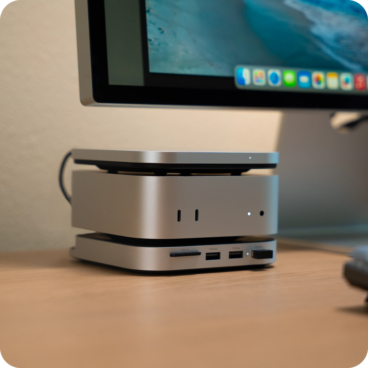 USB4 Slim NVMe SSD Enclosure under a Mac mini on a desk, with a monitor