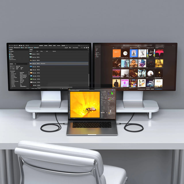 Satechi USB4 Pro Cables connecting a MacBook Pro to two monitors on a white dual monitor stand.