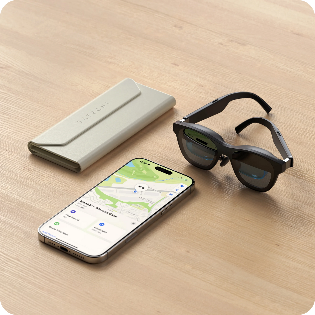 Vegan-Leather FindAll Glasses Case in Sand on a table with smart glasses and an iPhone showing Find My