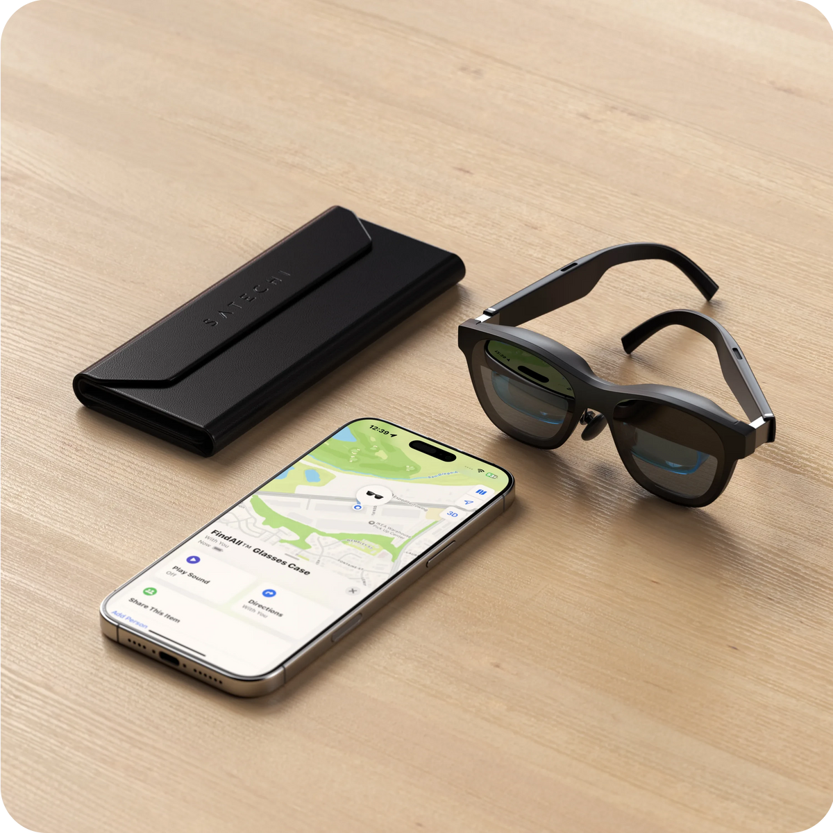 Vegan-Leather FindAll Glasses Case in Black on a table with smart glasses and an iPhone showing Find My