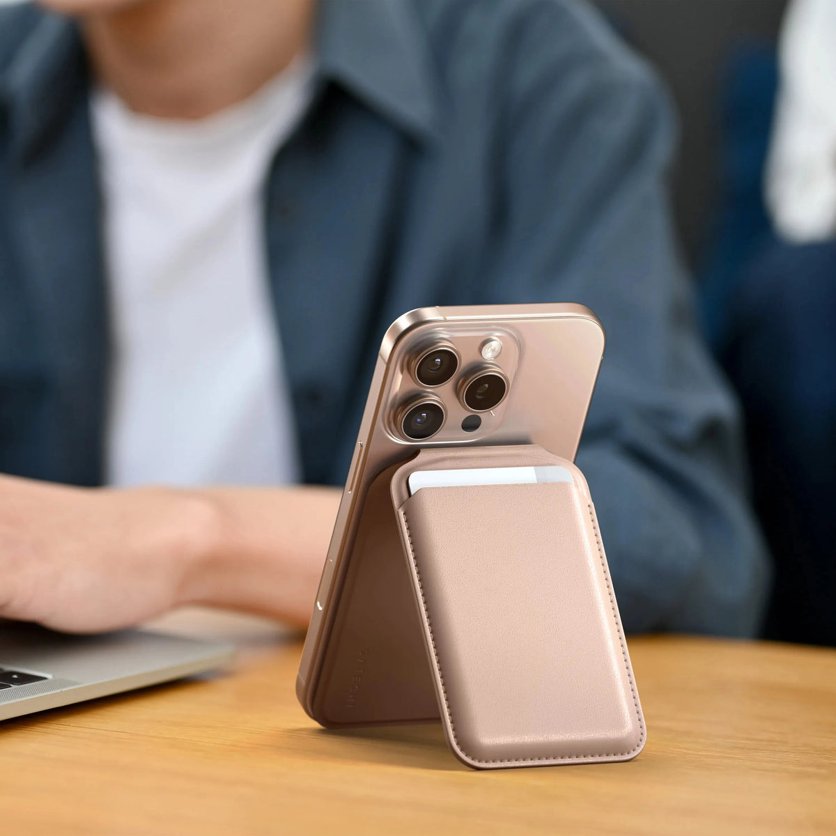 Vegan-Leather Magnetic Wallet Stand in Desert Rose propping up an iPhone next to a laptop