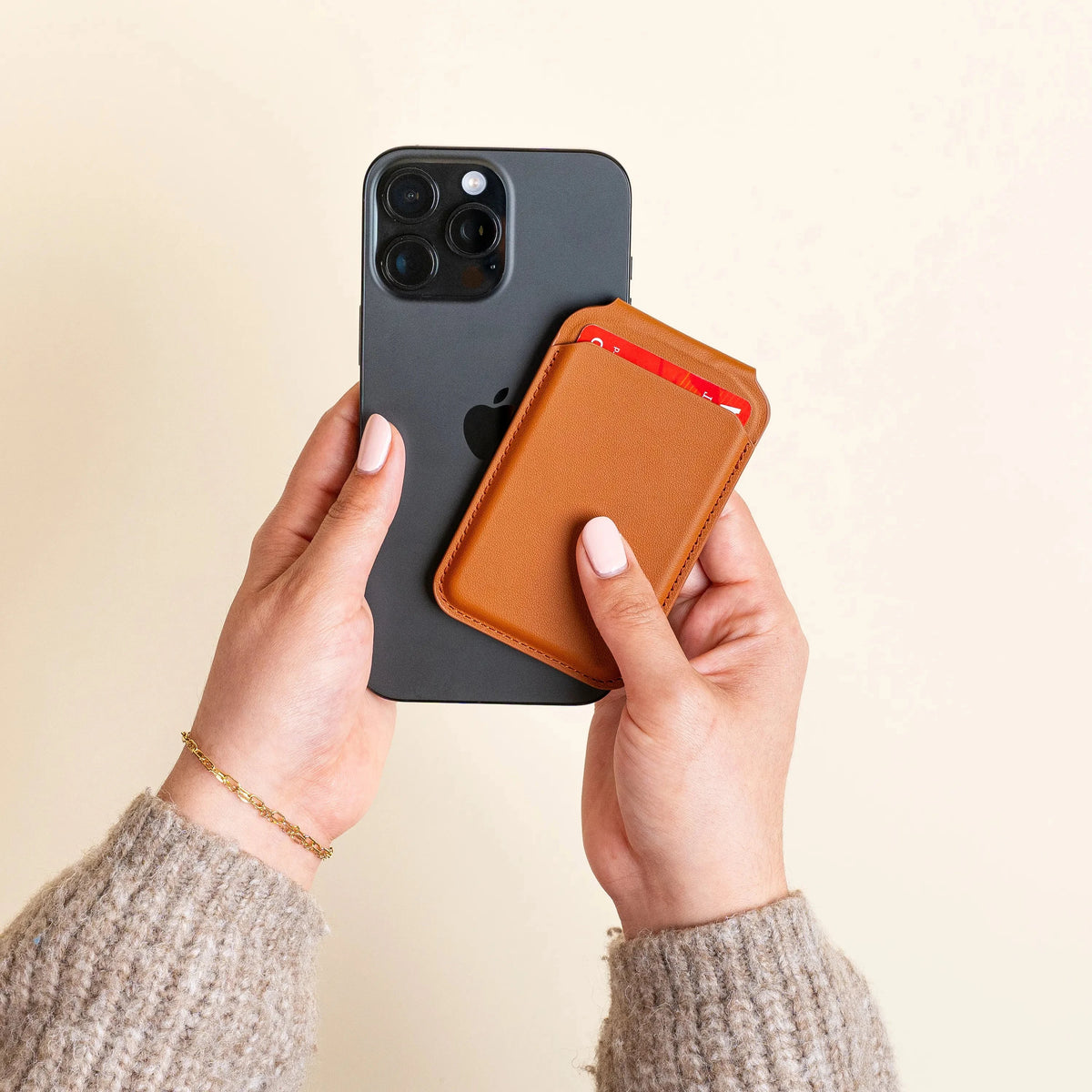 Hands attaching the Vegan-Leather Magnetic Wallet Stand in Brown to the back of an iPhone