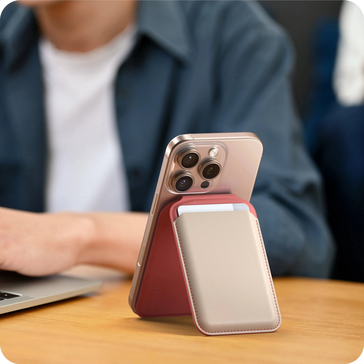 Vegan-Leather Magnetic Wallet Stand in Coral Pink and Taupe propping up an iPhone next to a laptop