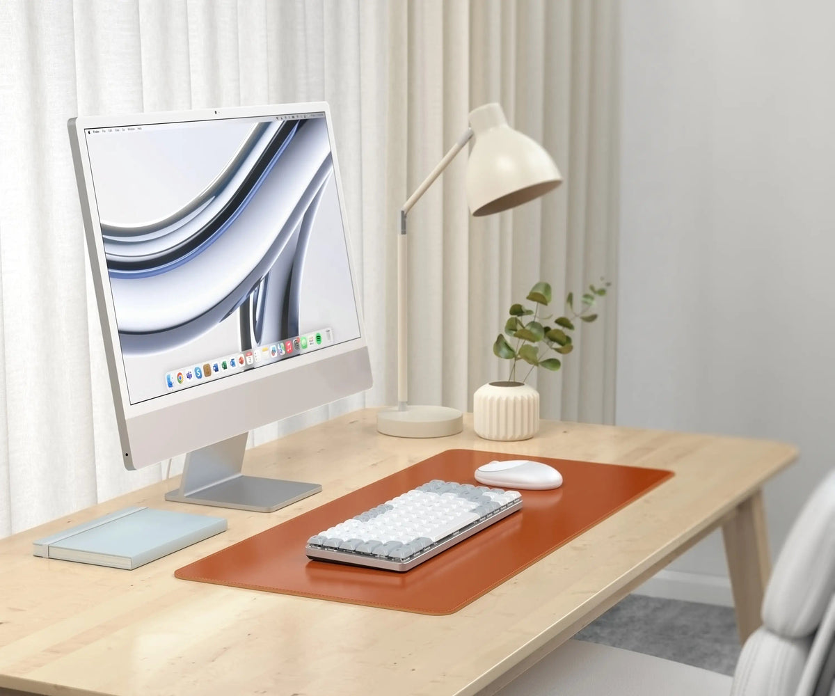 Vegan-Leather Premium Desk Mat in Brown on a desk with an iMac, keyboard and lamp