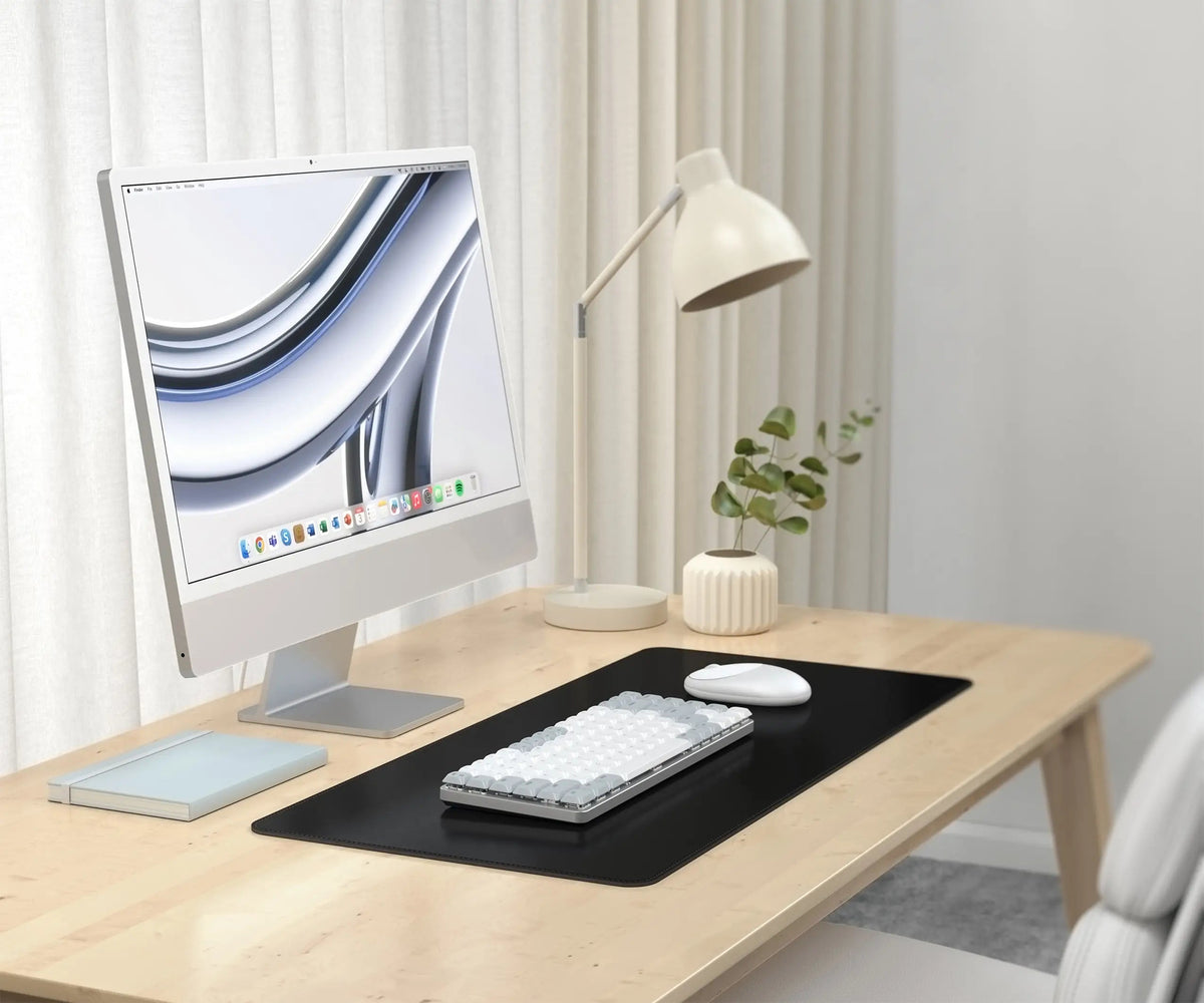 Vegan-Leather Premium Desk Mat in Black on a desk with an iMac, keyboard and lamp