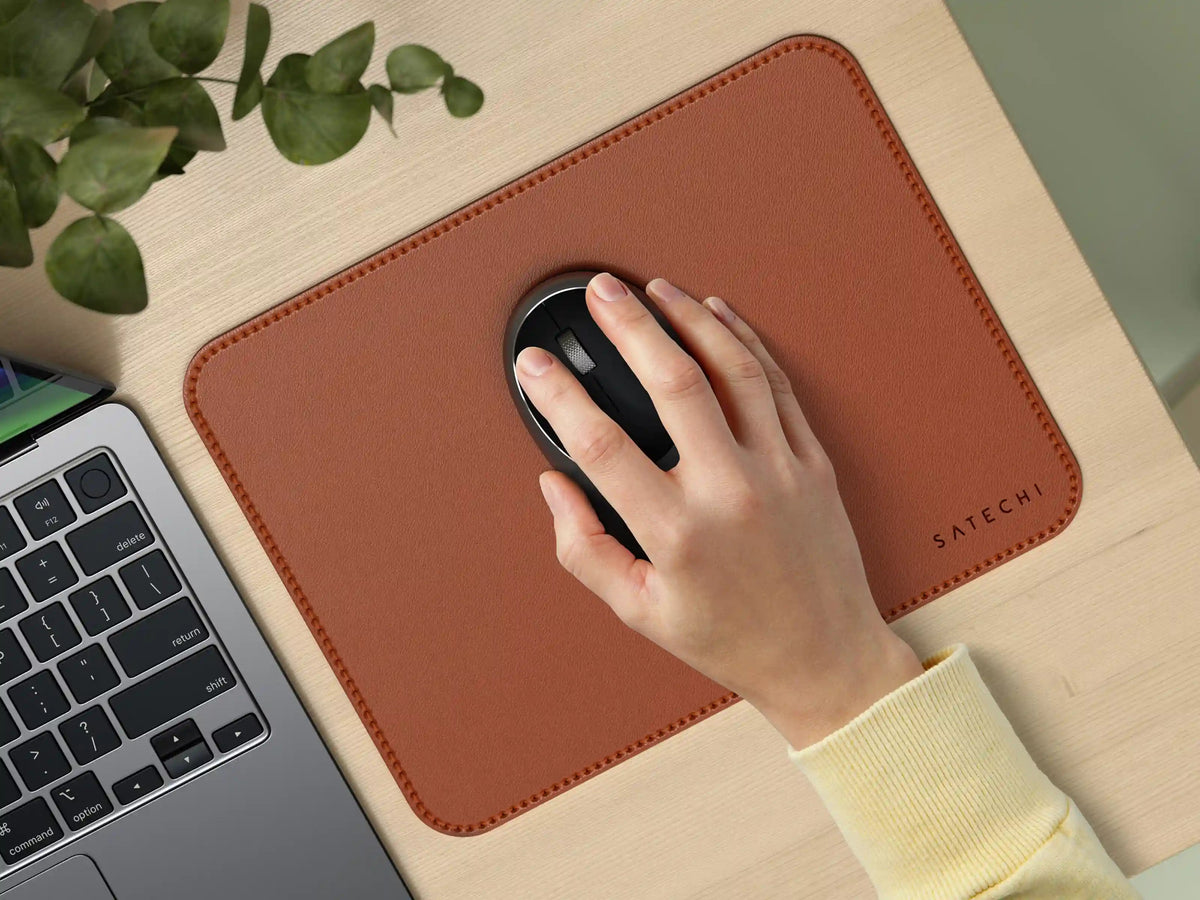 Hand using a mouse on the Vegan-Leather Premium Mouse Pad in Brown next to a laptop
