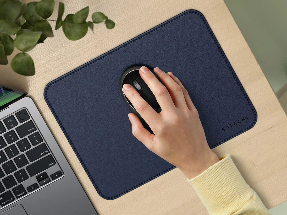 Hand using a mouse on the Vegan-Leather Premium Mouse Pad in Blue next to a laptop