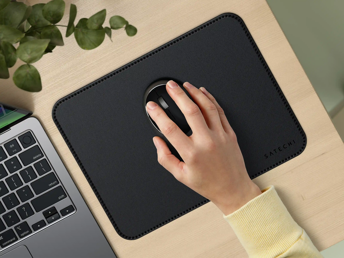 Hand using a mouse on the Vegan-Leather Premium Mouse Pad in Black next to a laptop