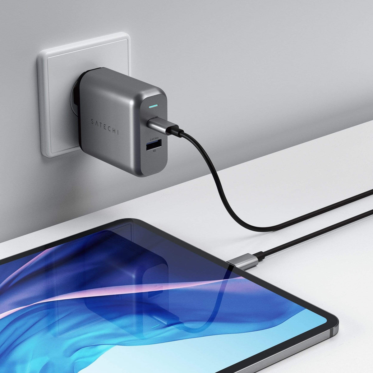 30W Dual-Port Wall Charger in a wall outlet charging an iPad