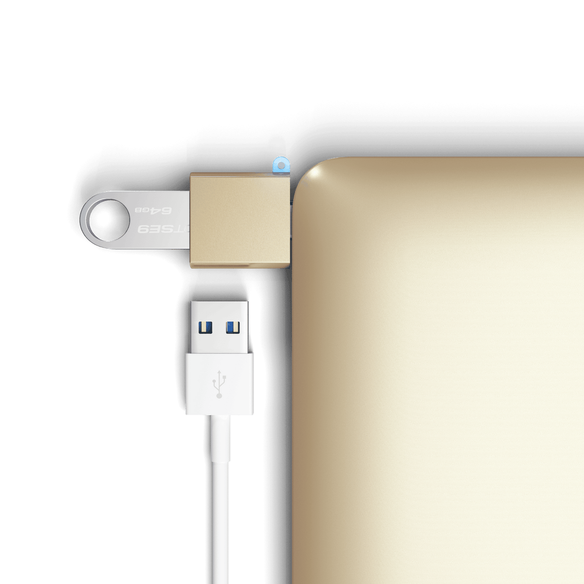 Aluminum USB-C to USB-A 3.0 Adapter in Gold plugged into a laptop with a flash drive and USB cable, close up
