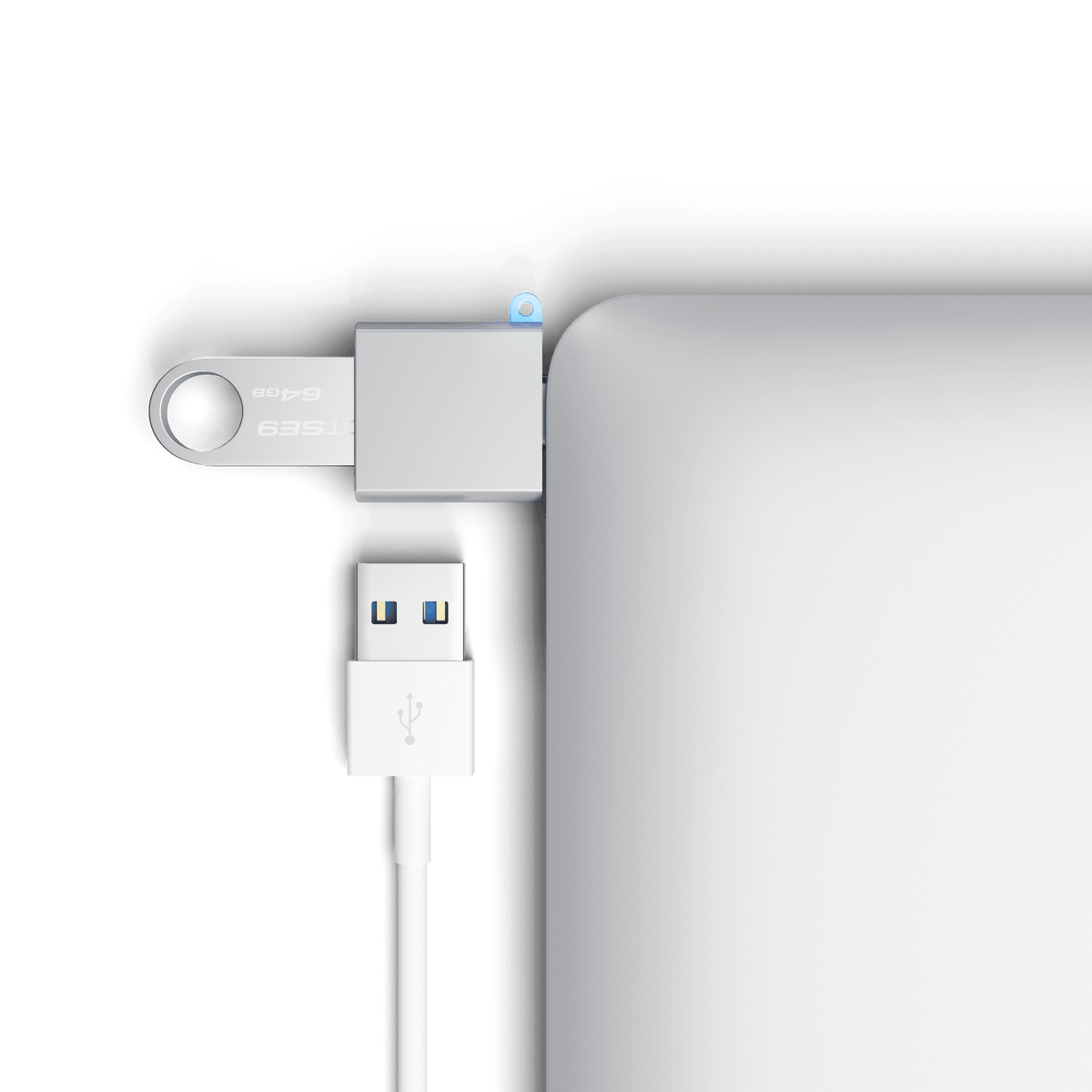 Aluminum USB-C to USB-A 3.0 Adapter in Silver plugged into a laptop with a flash drive and USB cable, close up