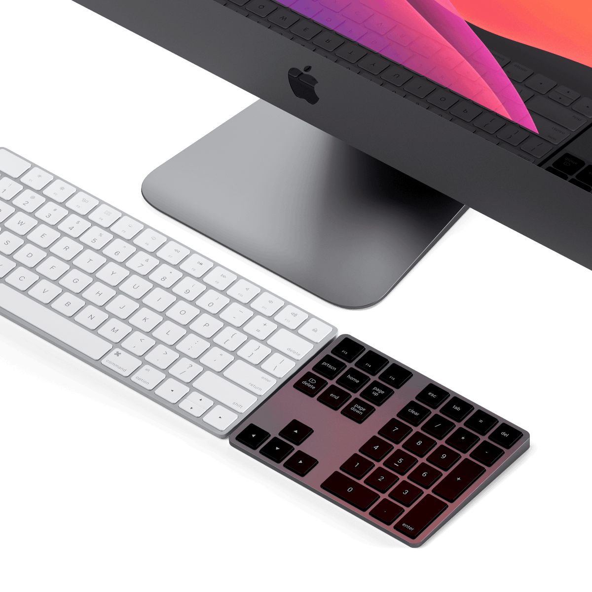 Bluetooth Extended Keypad in Space Gray next to a keyboard in front of an iMac