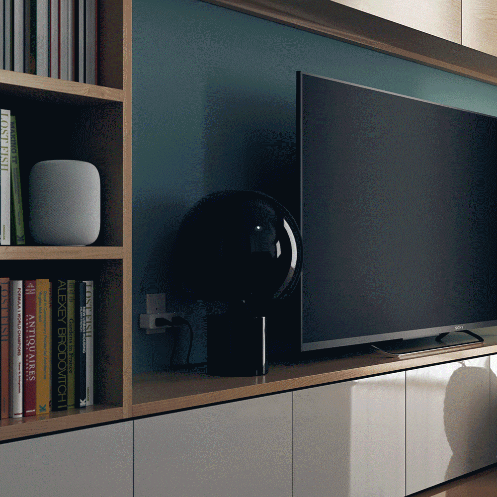 Dual Smart Outlet plugged in behind a TV stand in a living room