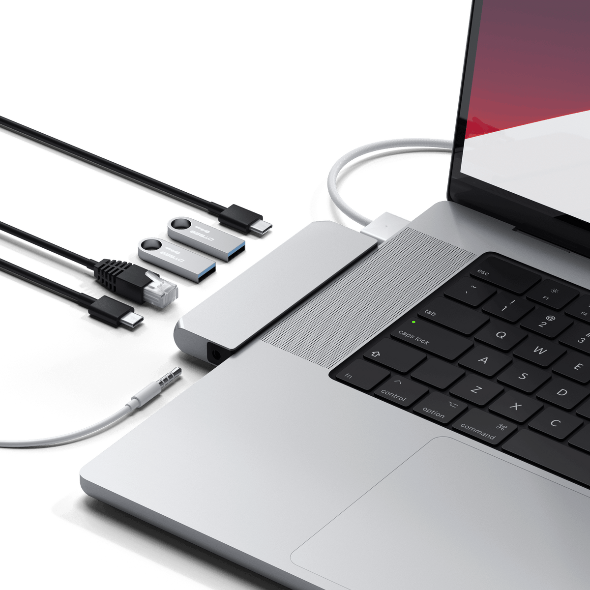 Pro Hub Mini in Silver plugged into a MacBook Pro with cables, flash drives and an Ethernet cable