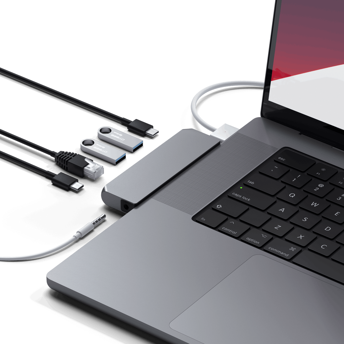 Pro Hub Mini in Space Gray plugged into a MacBook Pro with cables, flash drives and an Ethernet cable