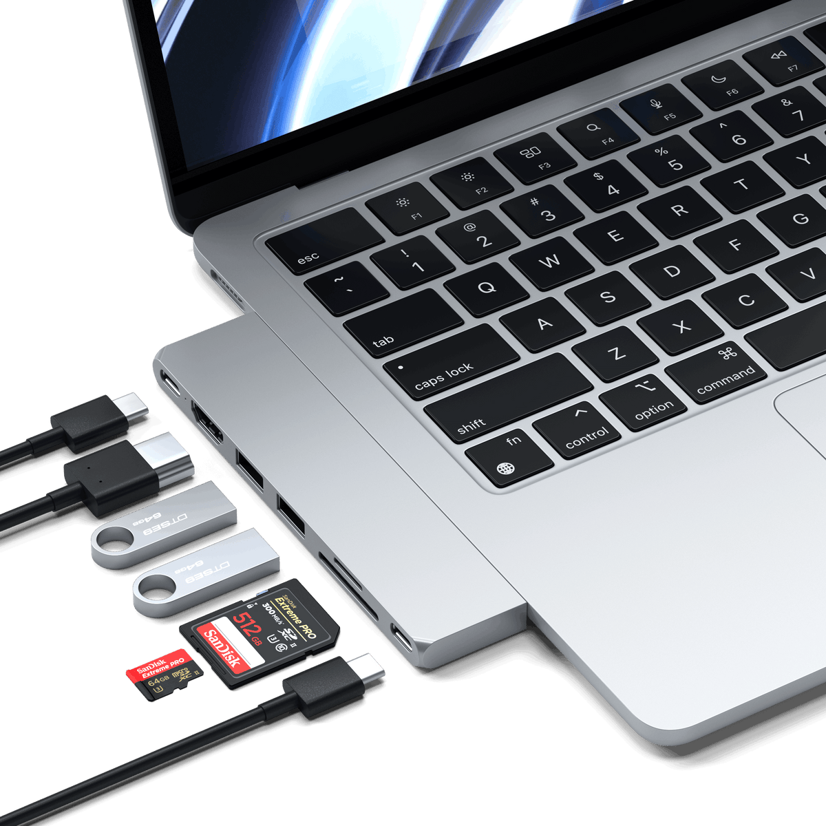 Pro Hub Slim in Silver plugged into an open MacBook with cables, flash drives and SD cards